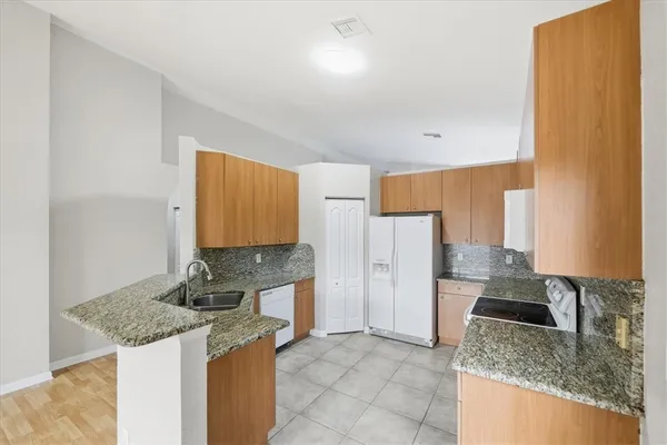 a kitchen with stainless steel appliances granite countertop a sink stove and refrigerator