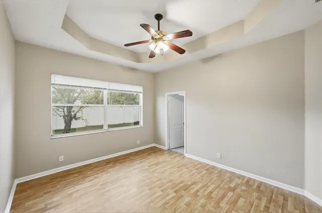 an empty room with window and ceiling fan