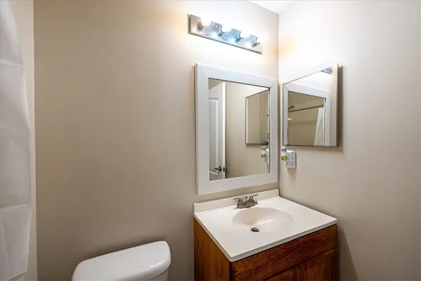 a bathroom with a toilet sink and mirror