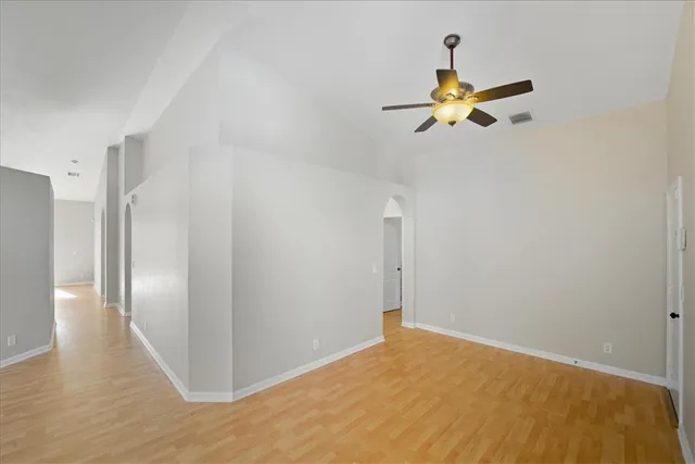a view of a room with wooden floor and a ceiling fan