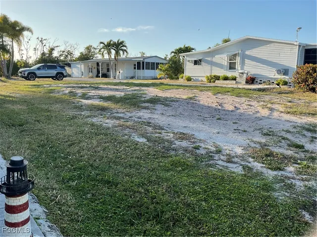 a view of a big house with a yard and sitting area
