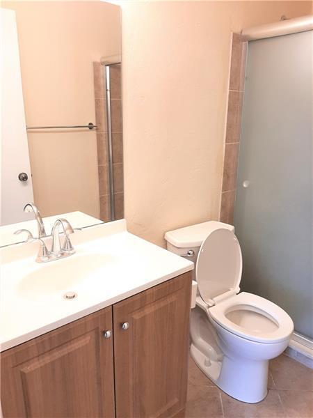 9466 Boca Cove Circle, Unit 310 Boca Raton, FL 33428 - Photo 16 of 22 a bathroom with a sink a toilet and mirror