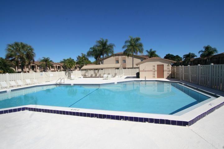 9466 Boca Cove Circle, Unit 310 Boca Raton, FL 33428 - Photo 20 of 22 a view of a swimming pool with a yard