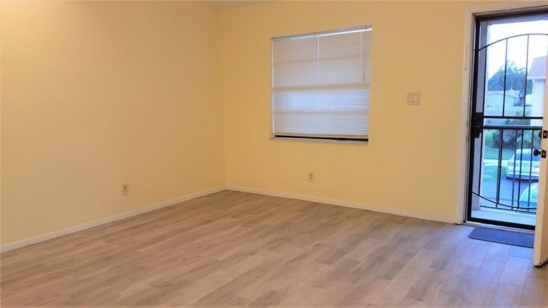 9466 Boca Cove Circle, Unit 310 Boca Raton, FL 33428 - Photo 2 of 22 an empty room with wooden floor and windows
