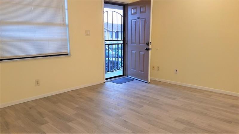 9466 Boca Cove Circle, Unit 310 Boca Raton, FL 33428 - Photo 3 of 22 an empty room with wooden floor and windows
