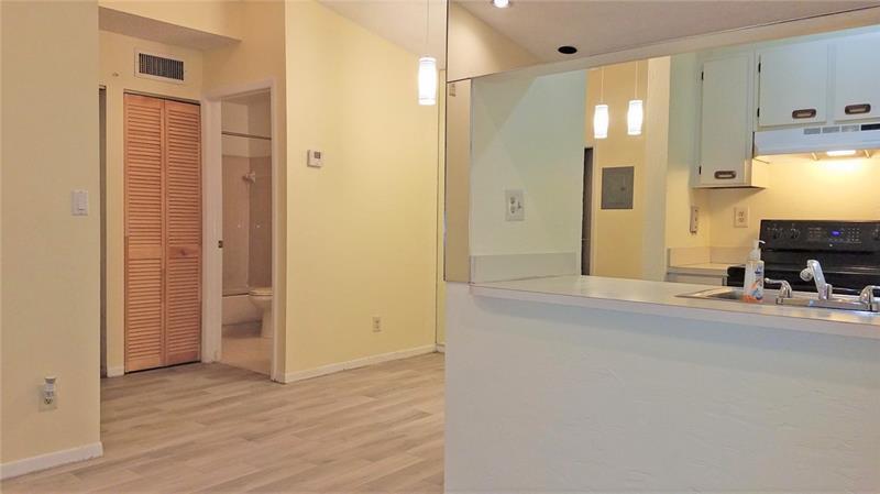 9466 Boca Cove Circle, Unit 310 Boca Raton, FL 33428 - Photo 5 of 22 a view of a hallway with wooden floor and a bathroom