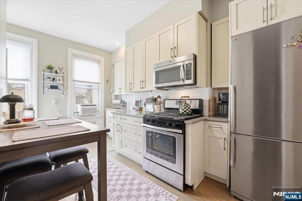63 Madison Street, Unit 6 Hoboken, NJ 07030 - Photo 5 of 16 a kitchen with stainless steel appliances granite countertop a stove a refrigerator and a microwave
