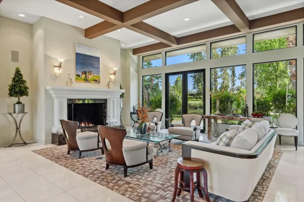 a living room with furniture a fireplace and a large window