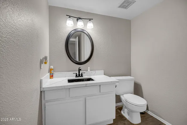 a bathroom with a toilet a sink and a mirror