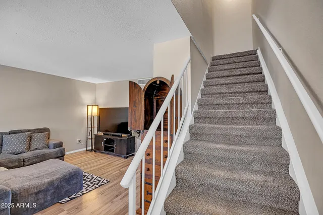a living room with furniture and stairs
