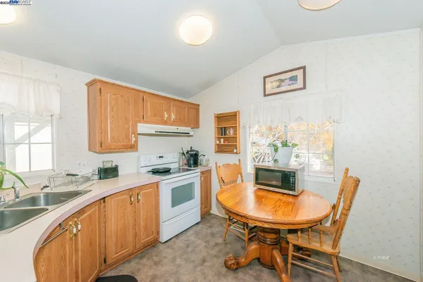 a large kitchen with stainless steel appliances kitchen island granite countertop a sink and cabinets