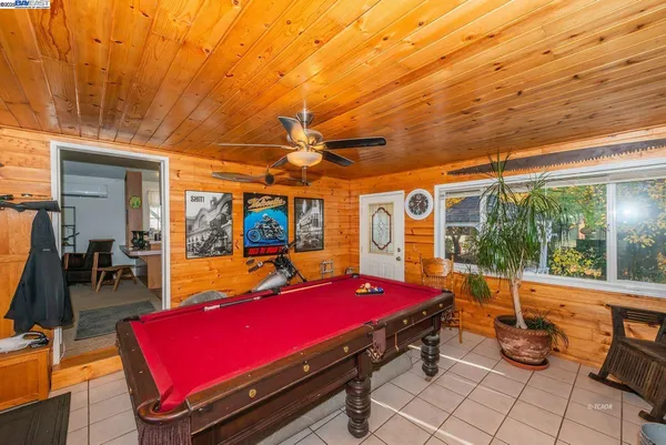 a room with pool table and windows