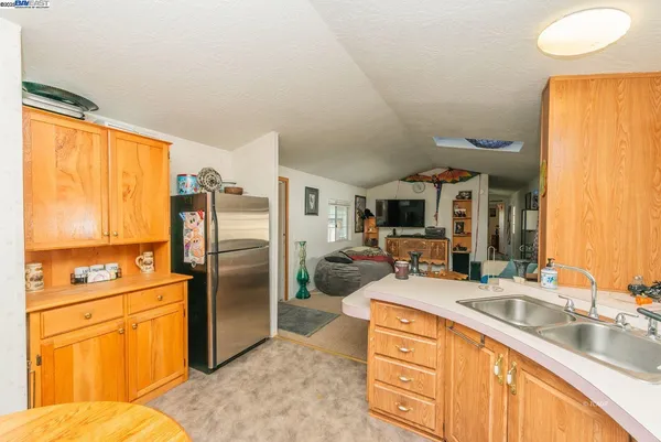 a kitchen with stainless steel appliances granite countertop a sink refrigerator and cabinets