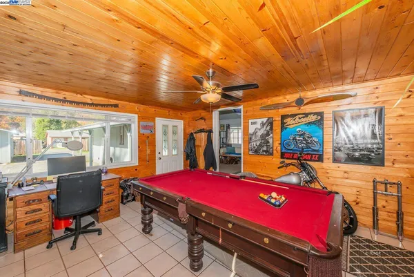 a room with pool table and glass windows