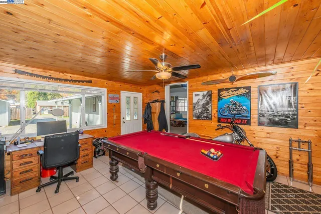a room with pool table and glass windows