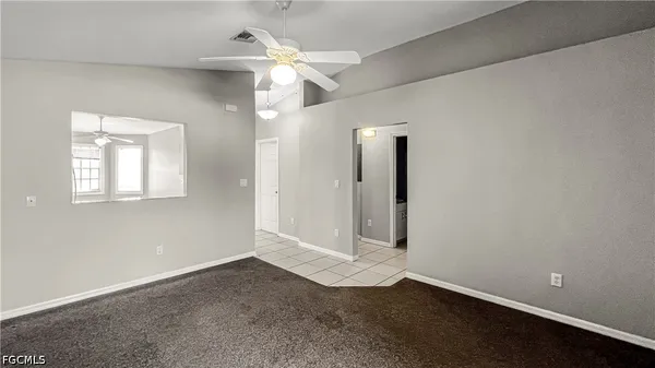 an empty room with a mirror and a fan