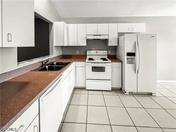 a kitchen with a stove a sink and a refrigerator