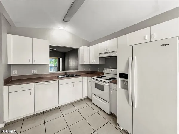 a kitchen with white cabinets a sink and white appliances