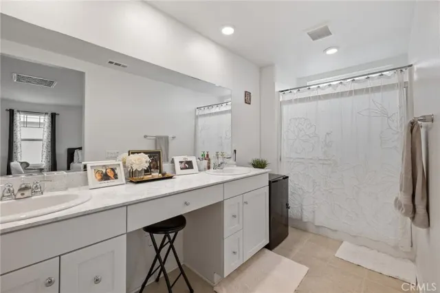 a bathroom with a double vanity sink mirror and shower