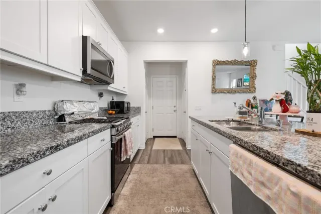a large kitchen with stainless steel appliances granite countertop a lot of counter space and a sink