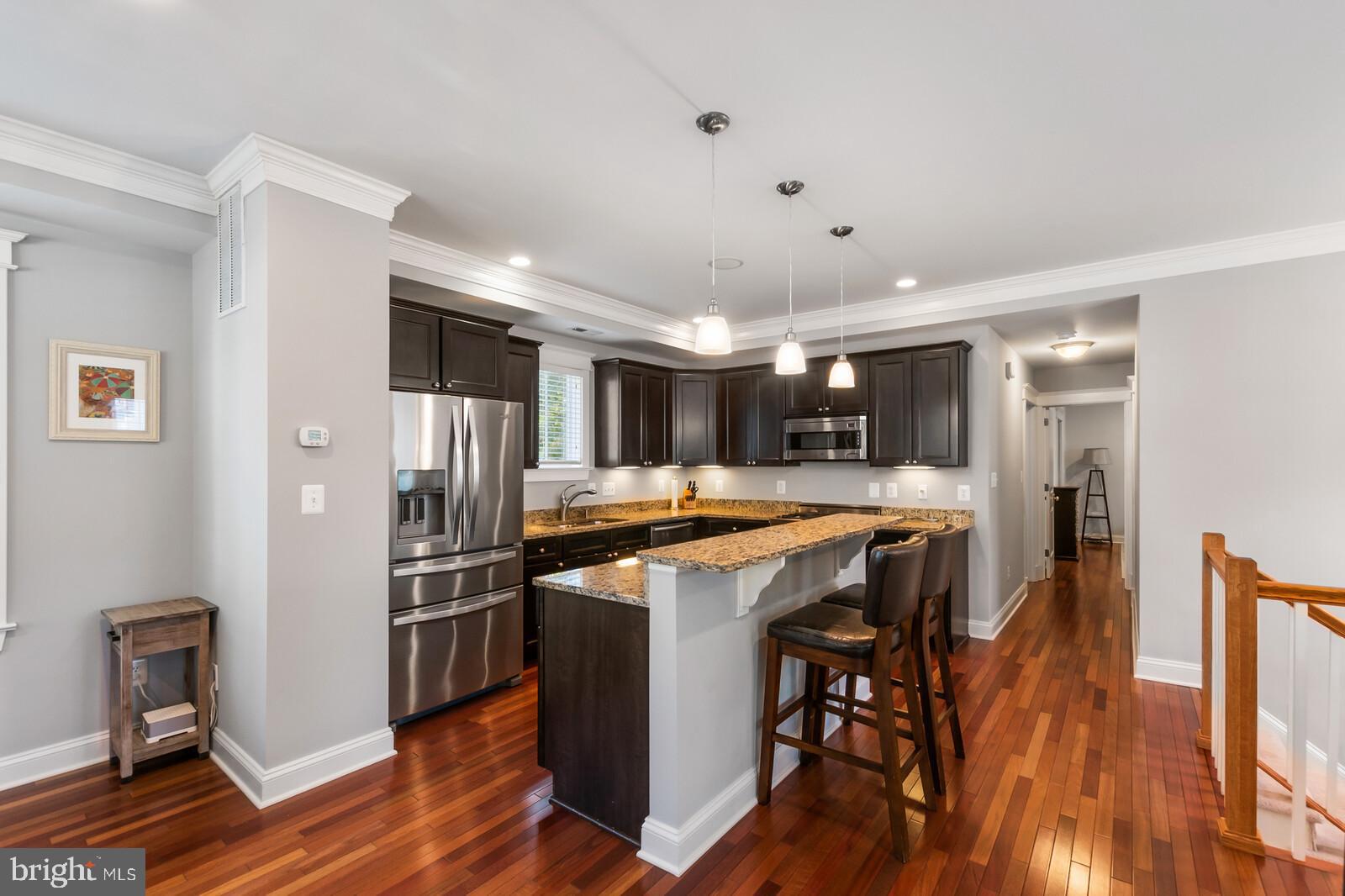 23 East Braddock Road Alexandria, VA 22301 - Photo 9 of 29 a kitchen with stainless steel appliances granite countertop a refrigerator a stove and a dining table with wooden floor