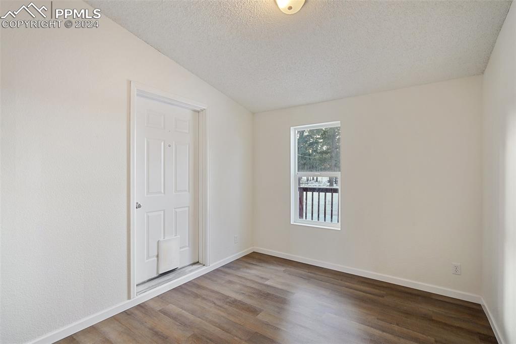 16625 Roller Coaster Road Colorado Springs, CO 80921 - Photo 16 of 44 an empty room with wooden floor and windows