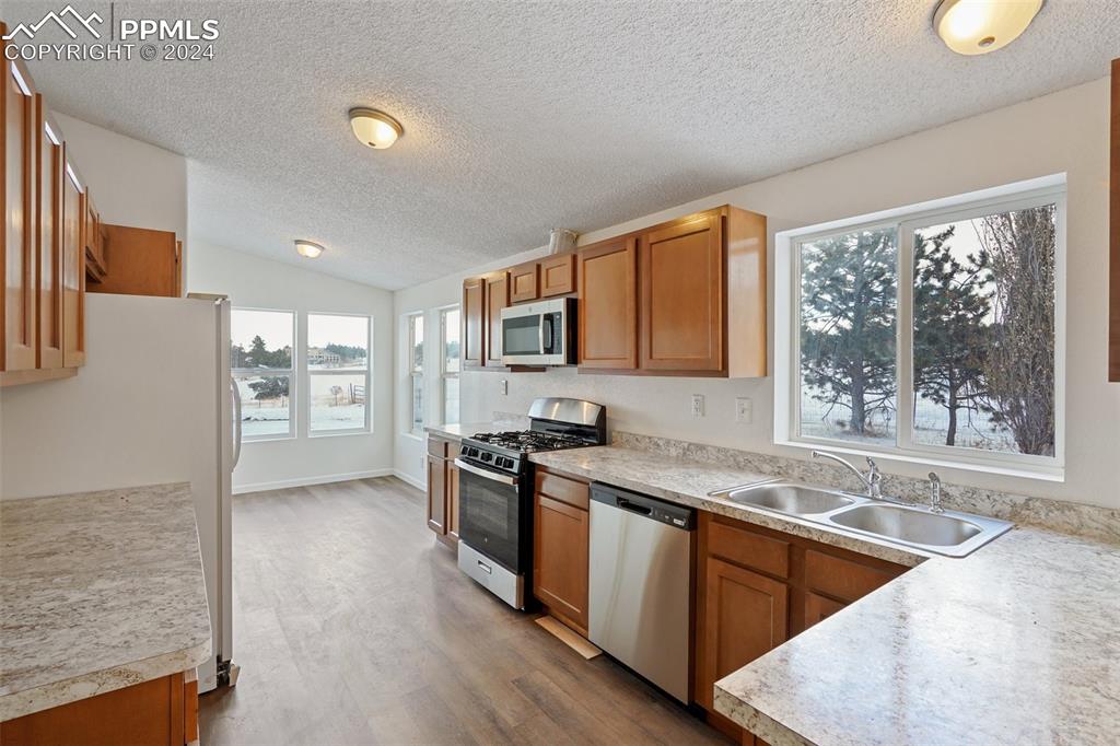 16625 Roller Coaster Road Colorado Springs, CO 80921 - Photo 26 of 44 a kitchen with stainless steel appliances granite countertop a sink stove and refrigerator