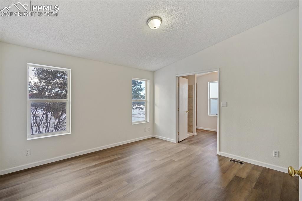 16625 Roller Coaster Road Colorado Springs, CO 80921 - Photo 30 of 44 an empty room with wooden floor and windows