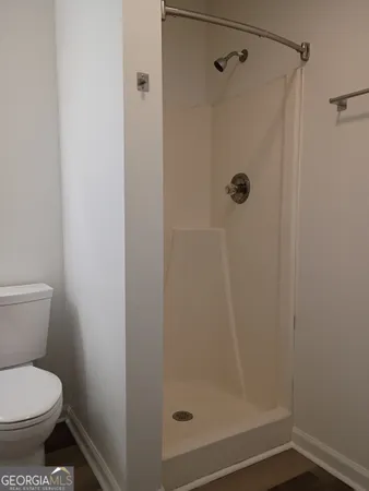 a bathroom with a toilet and a shower