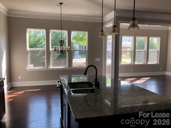 a kitchen with stainless steel appliances granite countertop a refrigerator a stove and a wooden floors
