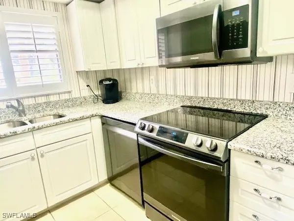a kitchen with granite countertop a sink and a stove top oven