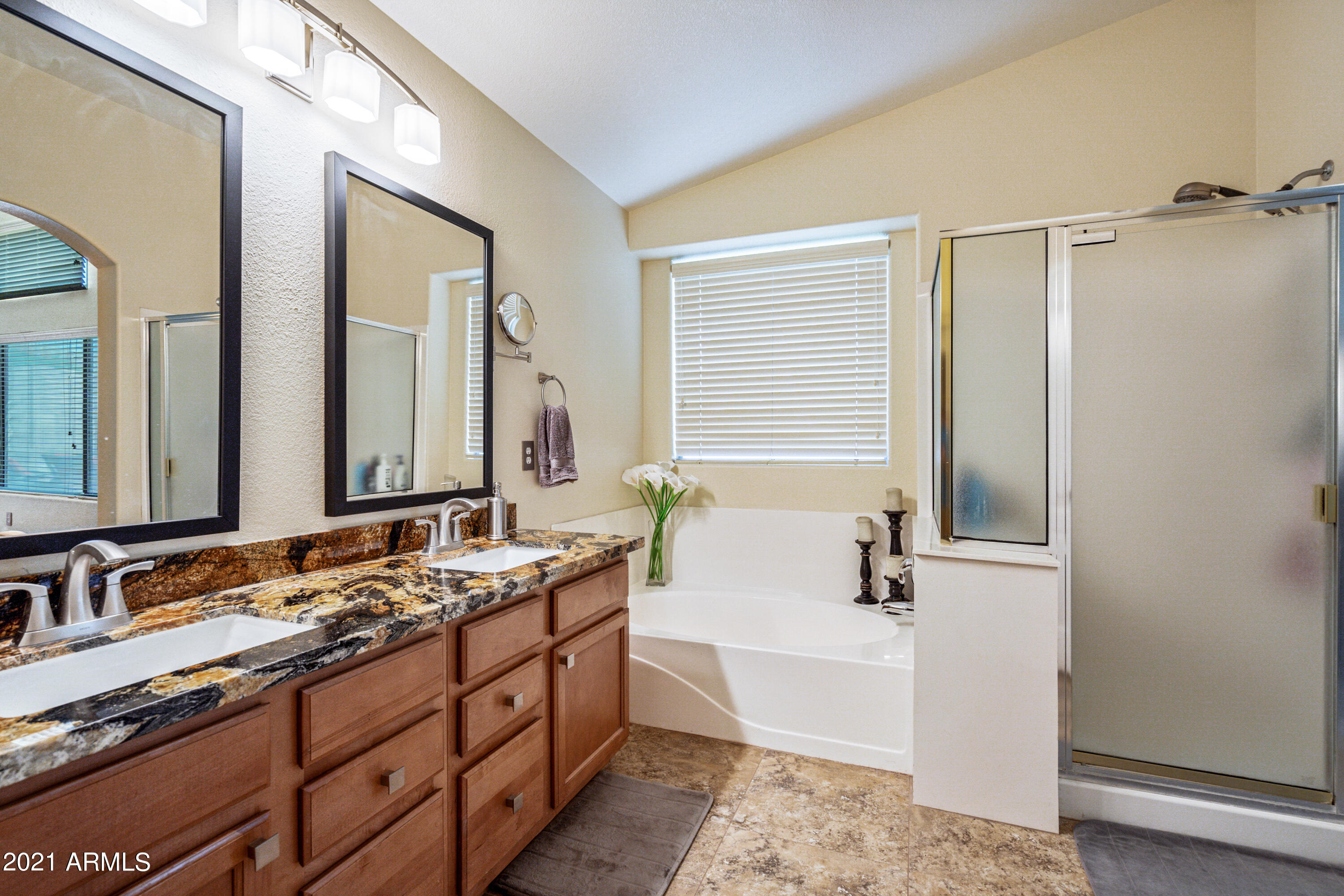 28726 North Nobel Road Phoenix, AZ 85085 - Photo 12 of 14 a spacious bathroom with double vanity a mirror a bathtub and shower