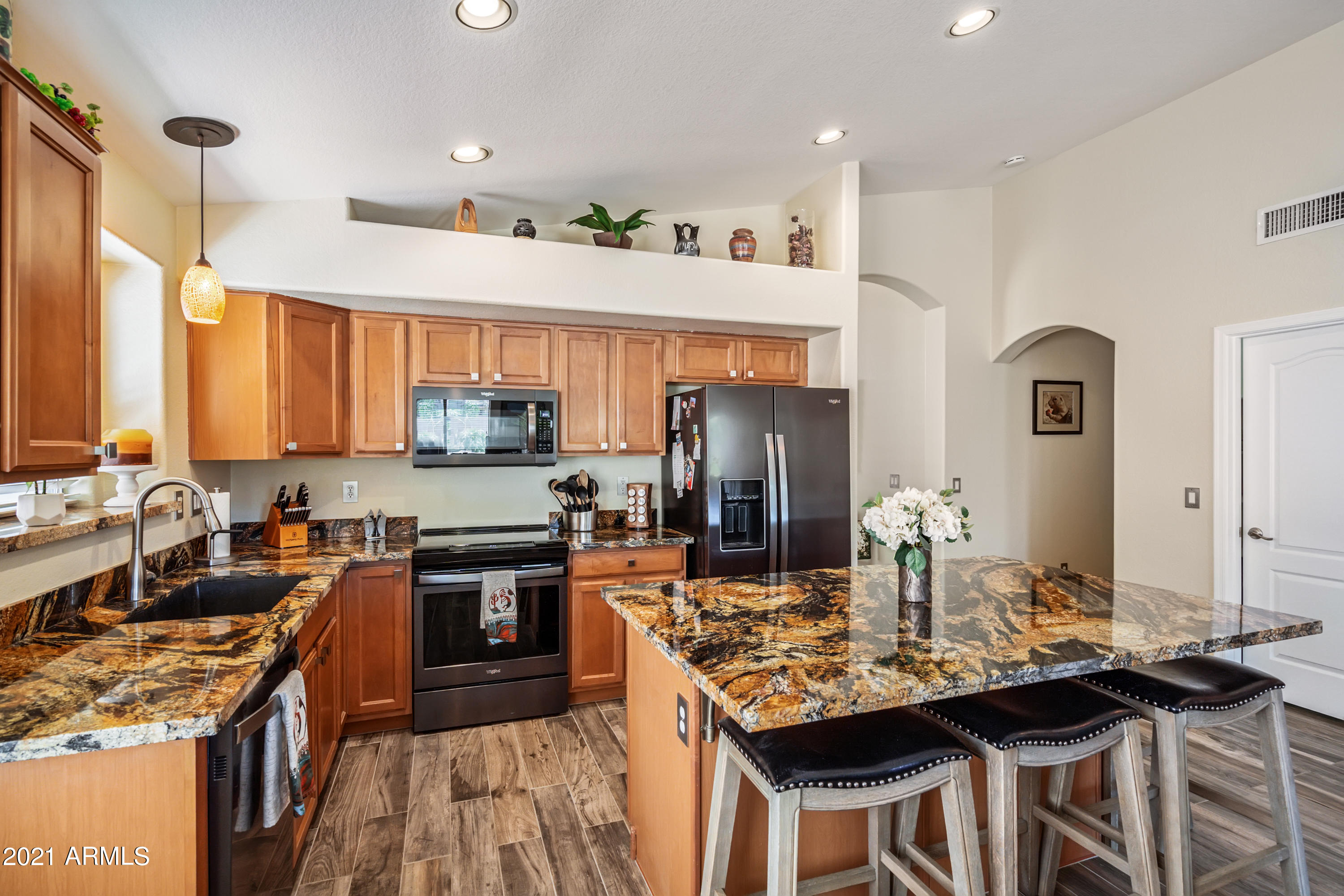 28726 North Nobel Road Phoenix, AZ 85085 - Photo 3 of 14 a kitchen with stainless steel appliances granite countertop a stove top oven a sink a dining table and chairs