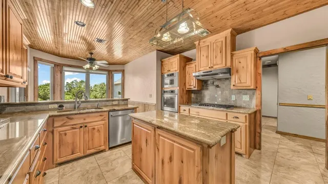 a kitchen with stainless steel appliances granite countertop a sink and cabinets
