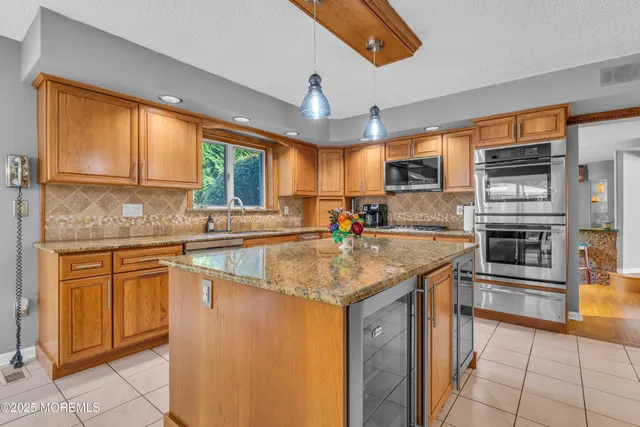 a kitchen with stainless steel appliances granite countertop sink stove top oven and cabinets