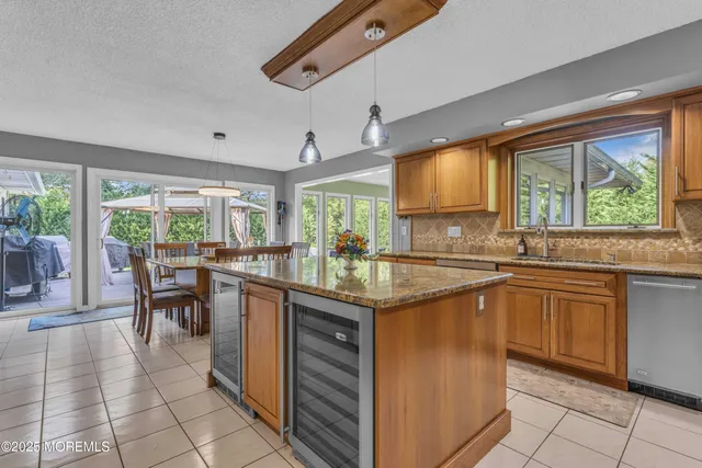 a kitchen with stainless steel appliances granite countertop a sink counter space cabinets and a large window