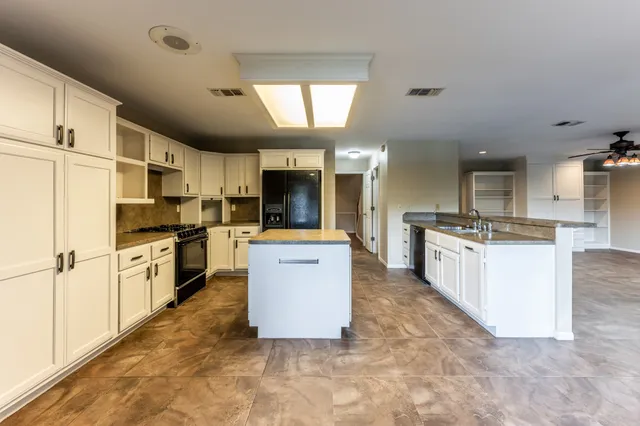 a large kitchen with cabinets and stainless steel appliances