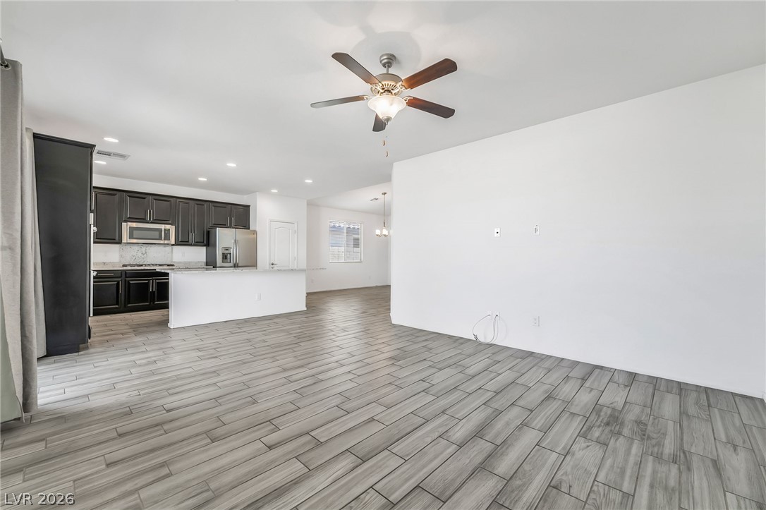 6245 Andover Wood Road Las Vegas, NV 89113 - Photo 16 of 37 An open-concept living space with sleek flooring flows into a contemporary kitchen, perfect for entertaining.