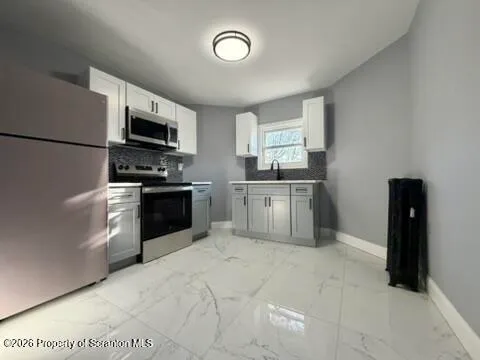 a kitchen with stainless steel appliances granite countertop a sink and dishwasher a stove top oven with wooden floor