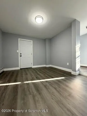 a view of empty room with wooden floor