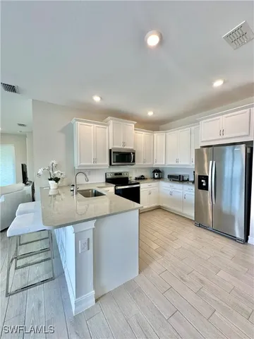 a kitchen with stainless steel appliances granite countertop a refrigerator sink and stove