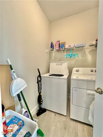 a view of a livingroom with wooden floor and a bathroom