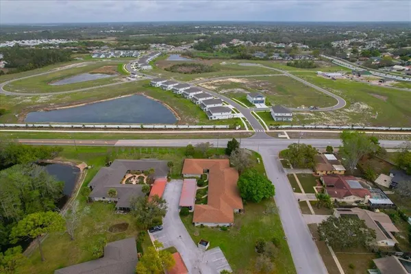 an aerial view of ocean and residential houses with outdoor space