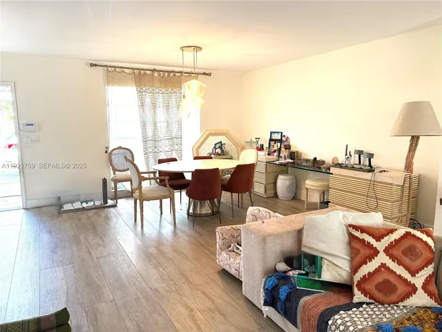 a large kitchen with stainless steel appliances kitchen island granite countertop a refrigerator oven a sink dishwasher and white cabinets with wooden floor