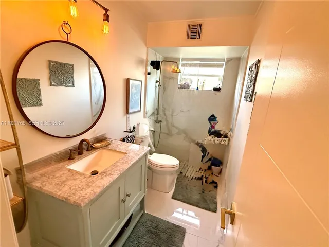 a bedroom with a bed and a large mirror on the dresser