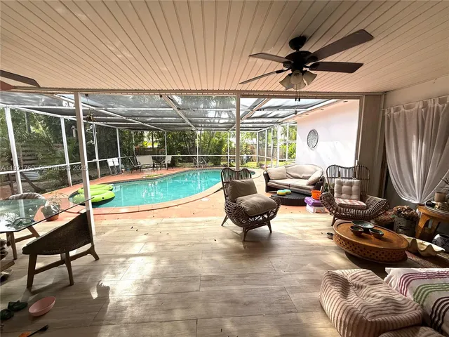 a living room with patio furniture and a garden