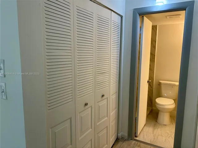 a white toilet sitting next to a shower curtain