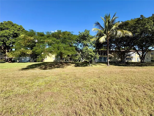 a view of a yard with yellow house