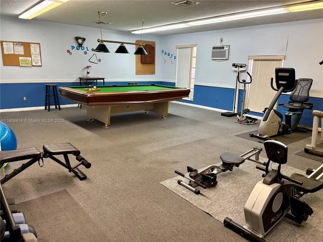 a room with gym equipment and a wooden floor