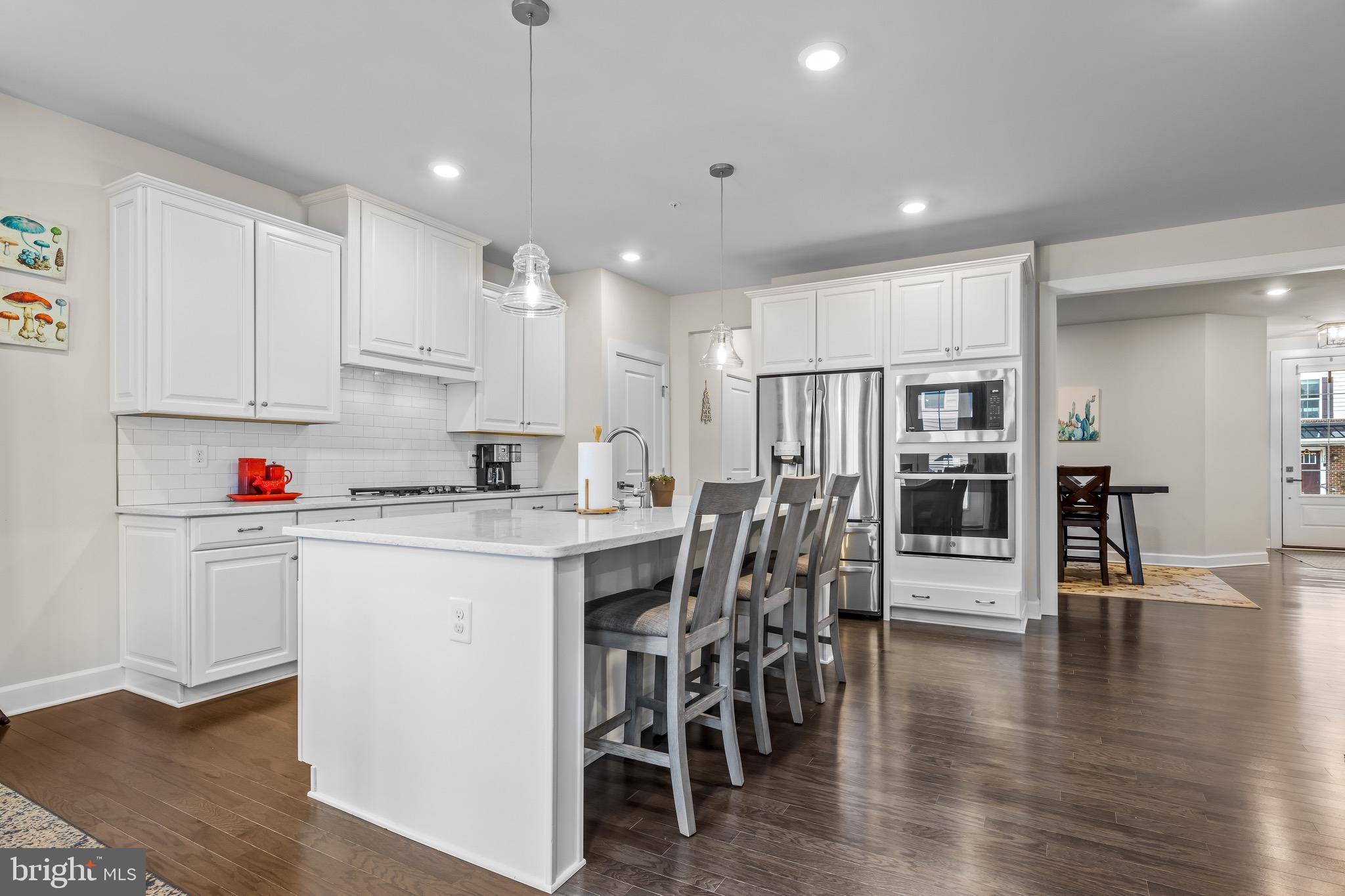 734 Quarry Point Road Malvern, PA 19355 - Photo 11 of 32 a kitchen with stainless steel appliances kitchen island granite countertop a table chairs refrigerator and a sink